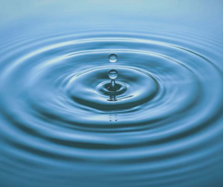 Close-up of a water droplet creating concentric ripples on a serene blue surface - gochisinsurance.com